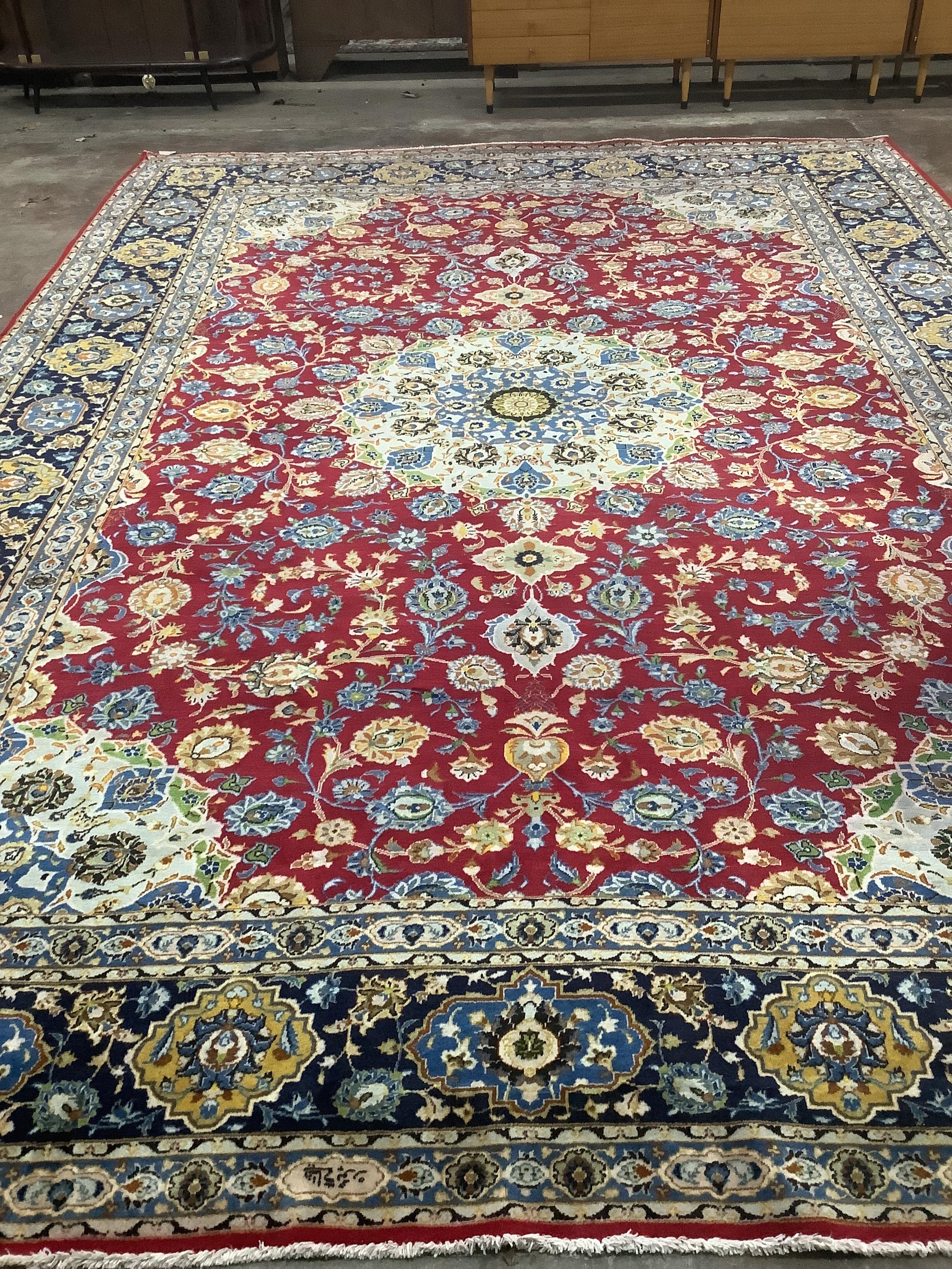 An Isphanan crimson ground carpet with central medallion and field of foliate motifs, multi-bordered, 425 x 300cm